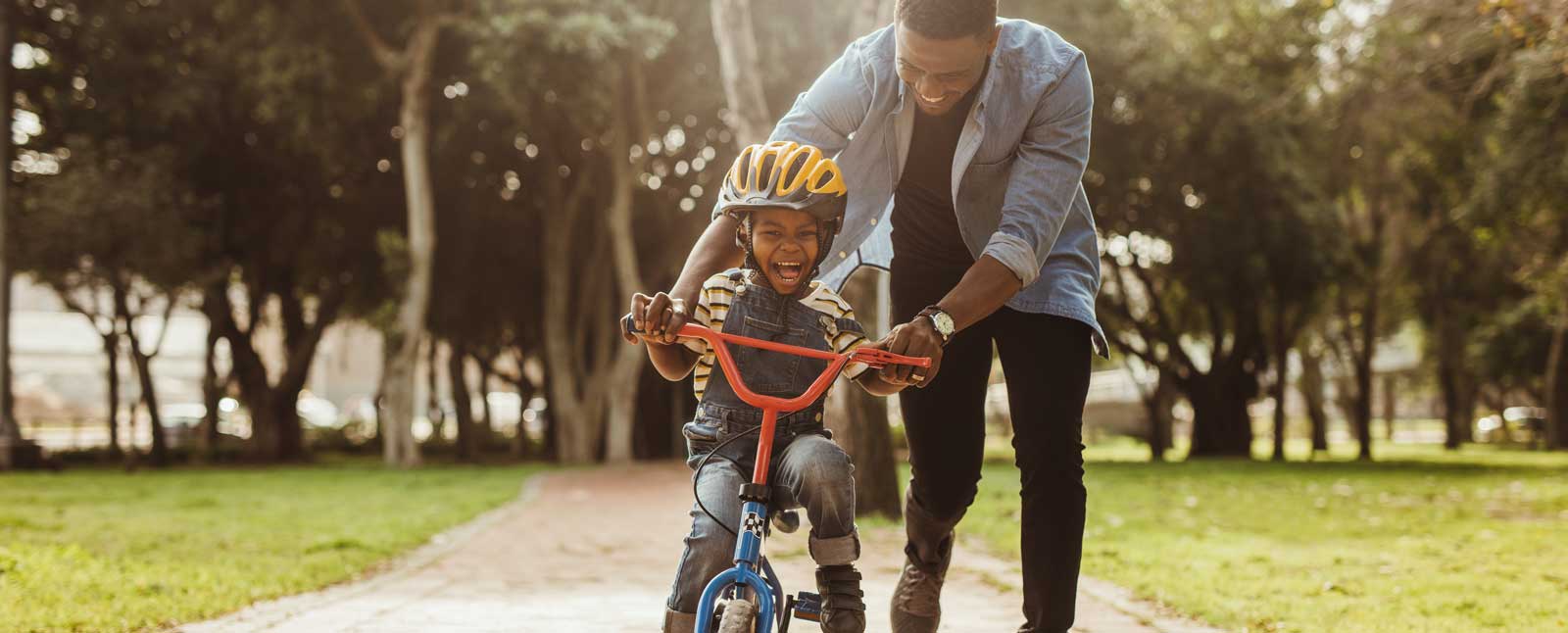 Dental Insurance - Dad teaching son how to ride a bike
